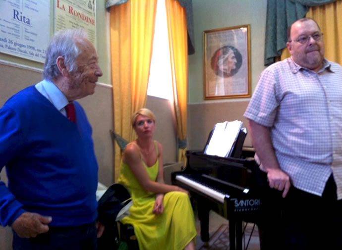 As pianist Ksenia Lelëtkina looks on, Benton Hess introduces Maestro Alberto Zedda.